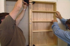 positioning the shelf unit between the studs