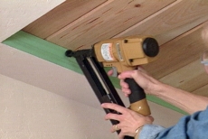 Using a nail gun to nail the trim into place.