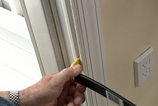 Using a pry bar to pull the interior trim away from the wall