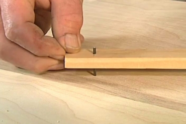 inserting the nail into the hole