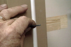 securing the exterior door assembly with finishing nails
