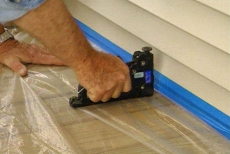 stapling plastic before staining and protecting a porch
