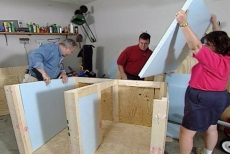 Inserting rigid foam insulation into the wall cavities