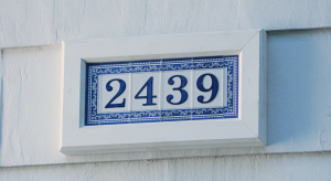 Man holding up completed house number sign