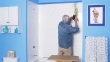 Man uses adhesive to adhere shower panel to wall