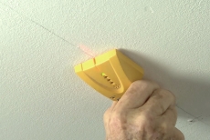 Using a finder with laser to locate ceiling joists 