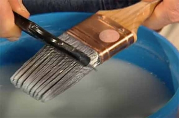 using a comb to clean a paintbrush