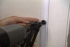 Using a nail gun to hang the trim