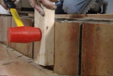 seating the tiles with a mallet and two-by-four