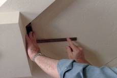 Using a bevel gauge to determine the angle of the ceiling panel