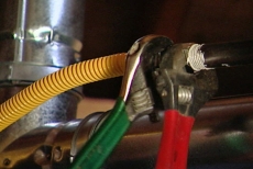 tightening the gas line connections with adjustable wrenches