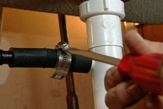 loosening the clamp on the dishwasher hose