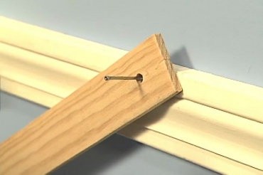 using a strip of wood to hold a nail