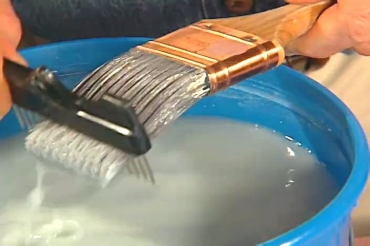 using a comb to clean a paintbrush