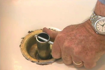 using a sink wrench to remove a sink drain basket