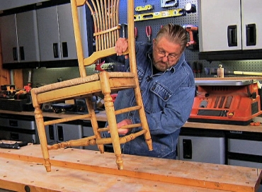 Man fixing wobbly chair in workshop