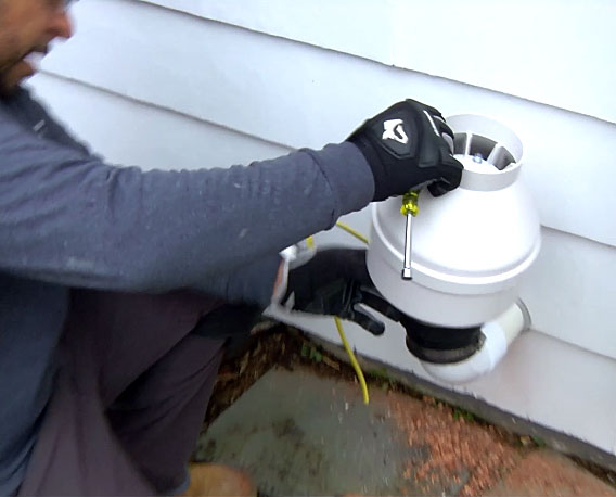 Man installing fan in exterior of home