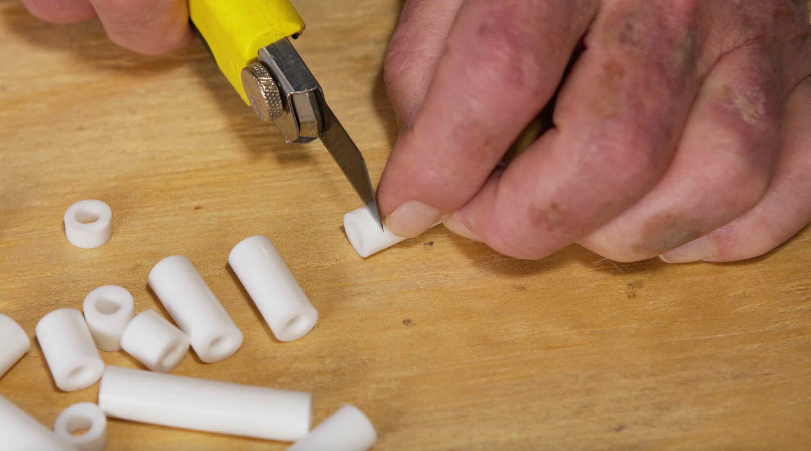 Man using utility knife to cut spacer for electrical outlet