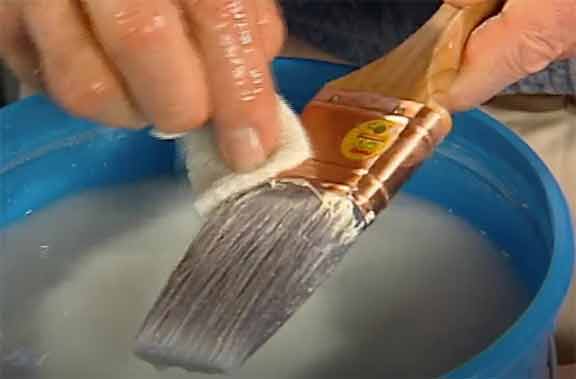 man cleaning paint brush