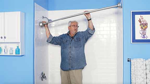 Man installing a tension curved shower rod