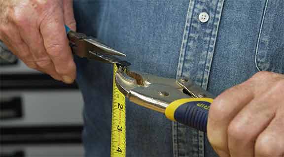 Man using pliers to fix tape measure