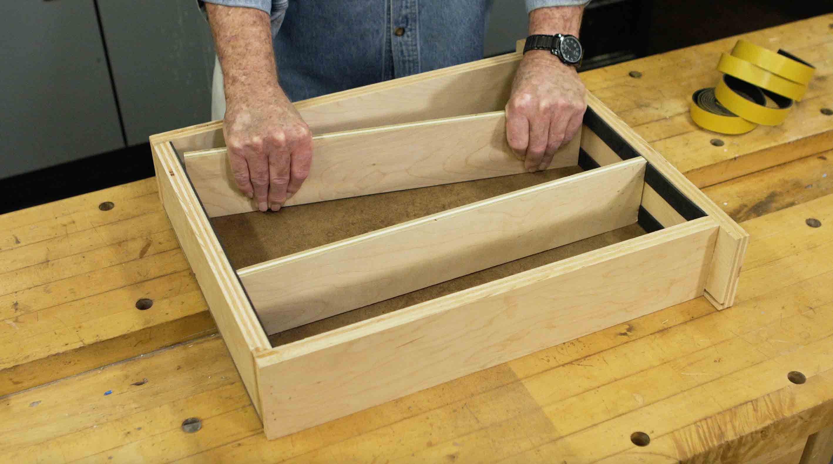 Man adjusts wooden drawer divider