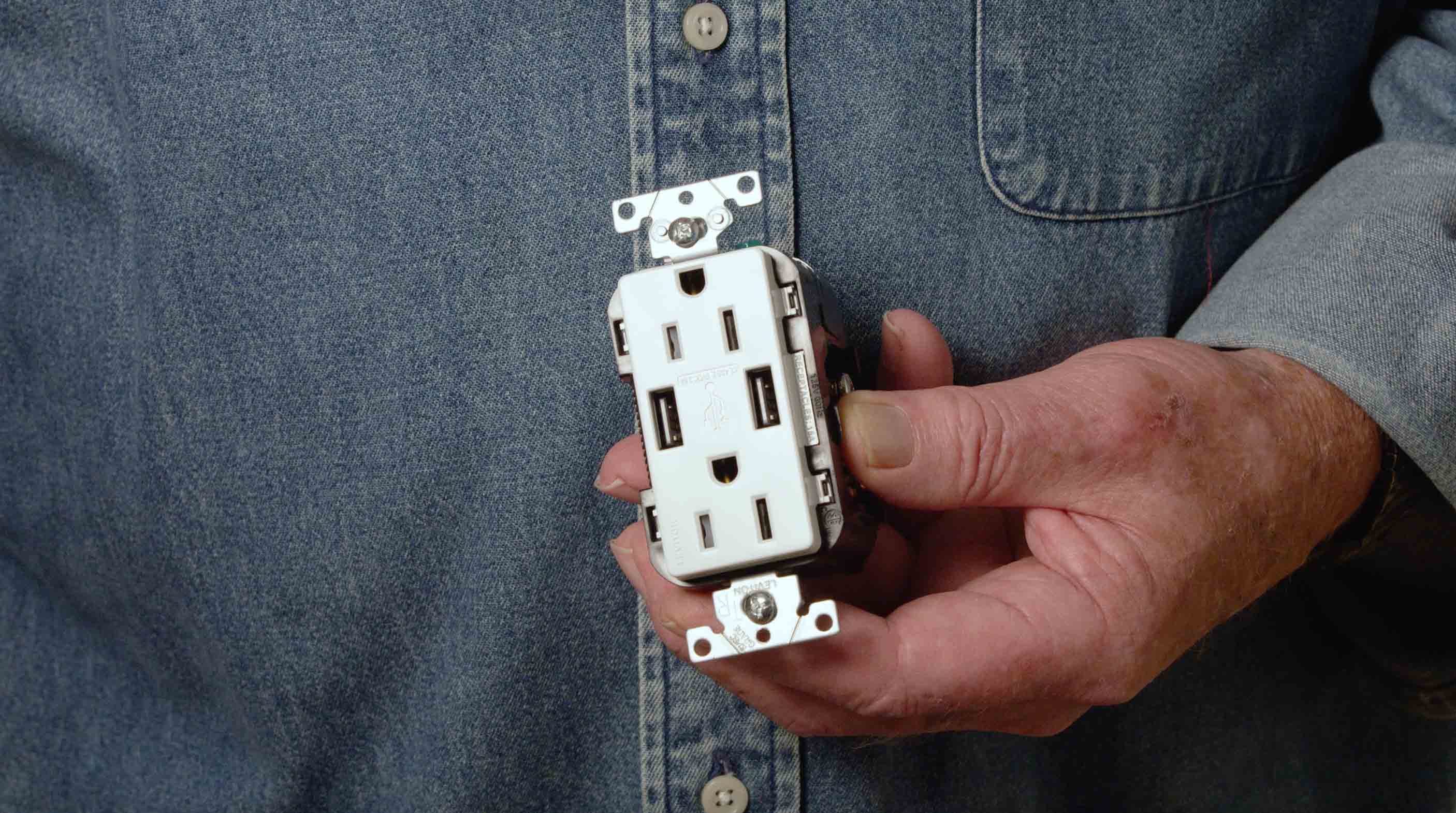 Man holding outlet with USB Plugs