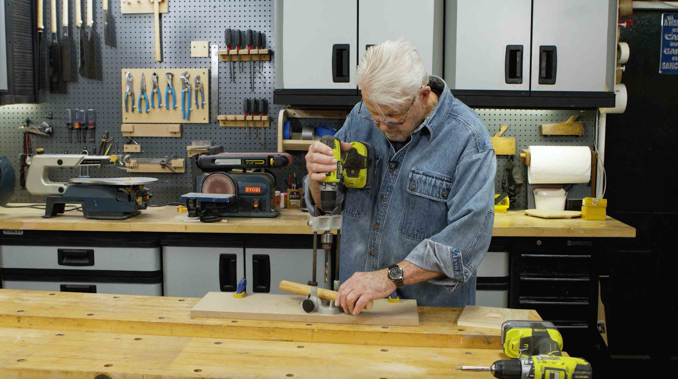 Man uses built in work support to drill into a dowel