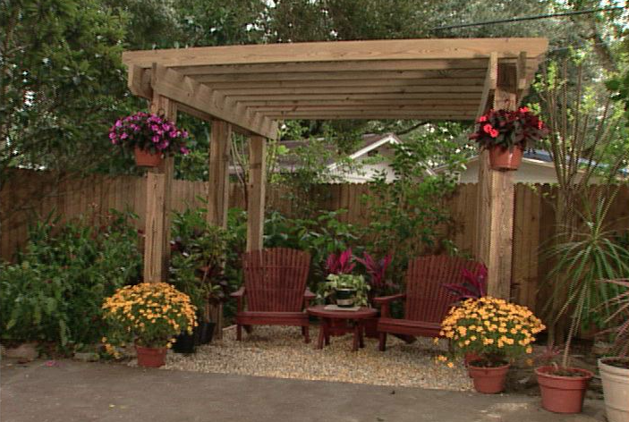 Wooden pergola outside with adirondack chairs and plants 