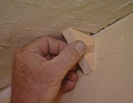 Placing molding block between ceiling and wall 
