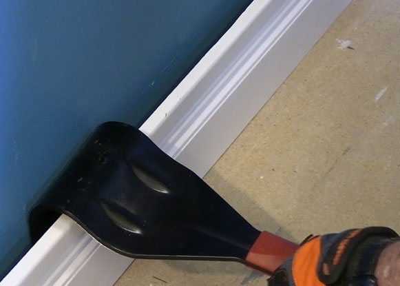 Man using Zenith industries trim puller to remove baseboard