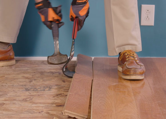 Man using Zenith Industries Floor Lifter to remove wooden flooring