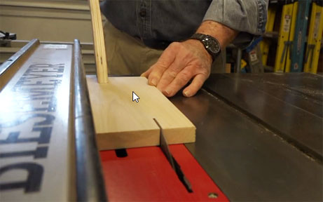 Man using table saw to cut wood 