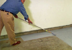 Applying Rustoleum EpoxyShield to the concrete garage floor using a roller