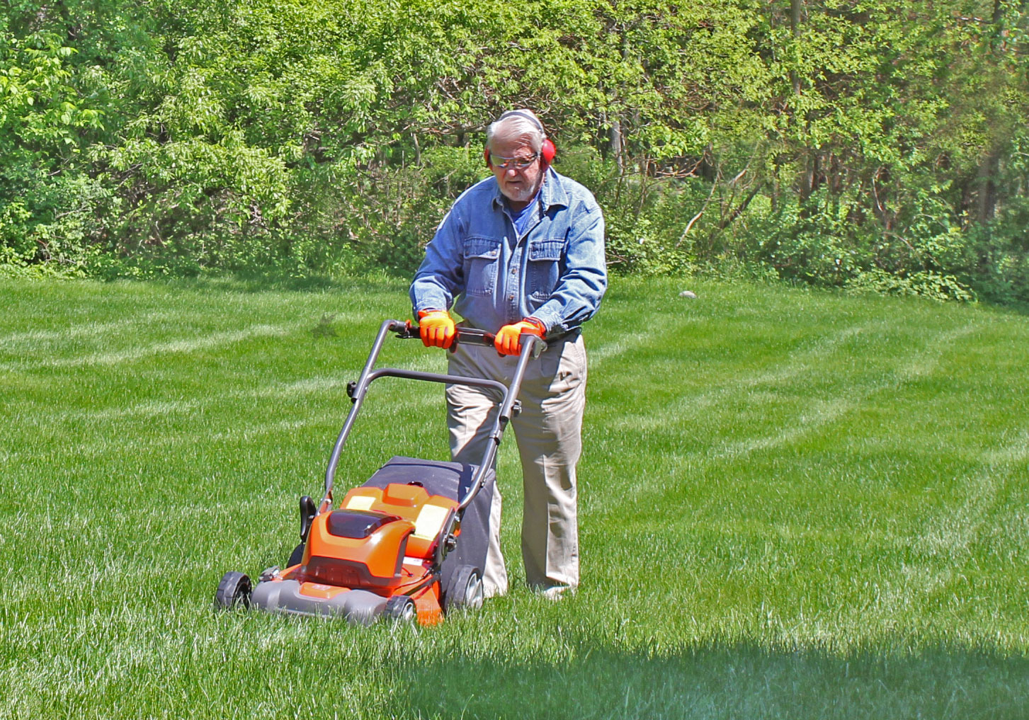 Man mowing lawn with ear protection