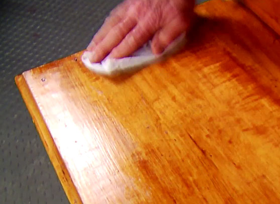 Wiping a naphtha on wooden table 